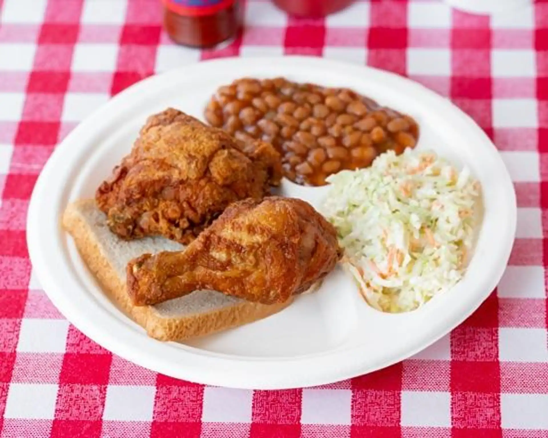 2 Piece Dark Plate - hand-battered, made to order thigh and leg, cooked to perfection in peanut oil and served with our savory baked beans, creamy coleslaw, and white bread.